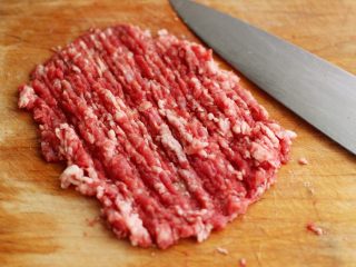 牛肉萝卜饼,把沥干水分的牛肉用刀切成小丁后再用刀剁成肉泥