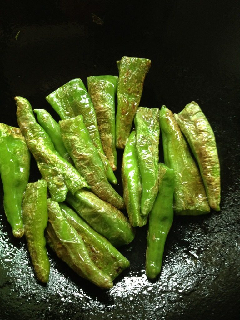 虎皮青椒,锅中倒油,中火待油4成熟时放青椒煎,把青椒的两面都煎成起