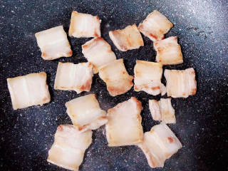 土豆回锅肉,锅中放入五花肉片，两面煎至金黄，练出猪油。