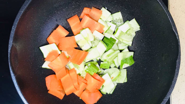 黄瓜烧豆腐,将蔬菜加入锅里，翻炒至蔬菜出水