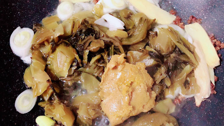 酸菜海鲜锅,放入酸菜和调料包炒匀。