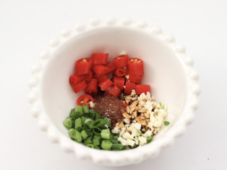 藤椒茼蒿肉片,碗里放入小米辣和葱叶，大蒜末和生抽，适量的盐。