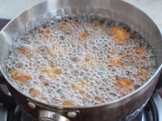 酥炸蘑菇,锅中倒适量食用油烧至七八成热，将杏鲍菇一个一个地下入锅中，中火炸制定型后用筷子轻轻翻动。