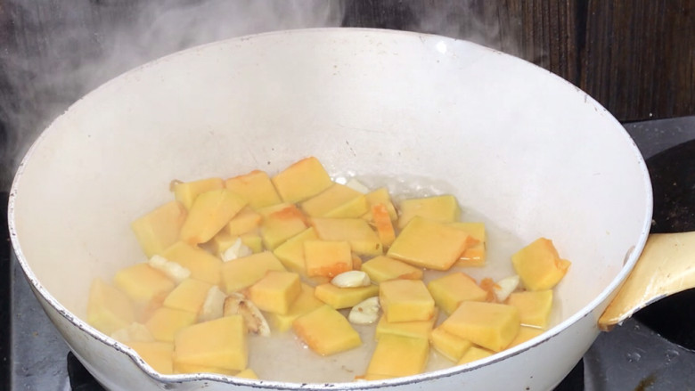 南瓜炒鸡蛋,就着油锅，放入蒜炒香，放入南瓜炒匀，加入适量清水盖上锅盖焖10分钟
