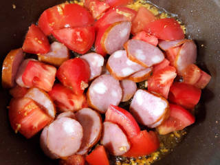 火腿青菜炒鸡蛋,放入肠和西红柿翻炒均匀。