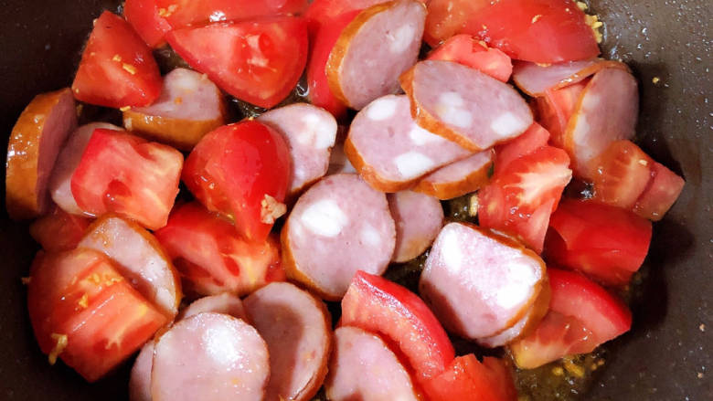 火腿青菜炒鸡蛋,放入肠和西红柿翻炒均匀。