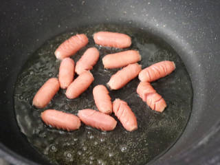 红肠沙拉水果时蔬,锅中倒入适量油烧热，放入红肠。
