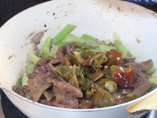 泡椒芹菜炒猪肝,放入猪肝和泡椒，翻炒均匀至入味
