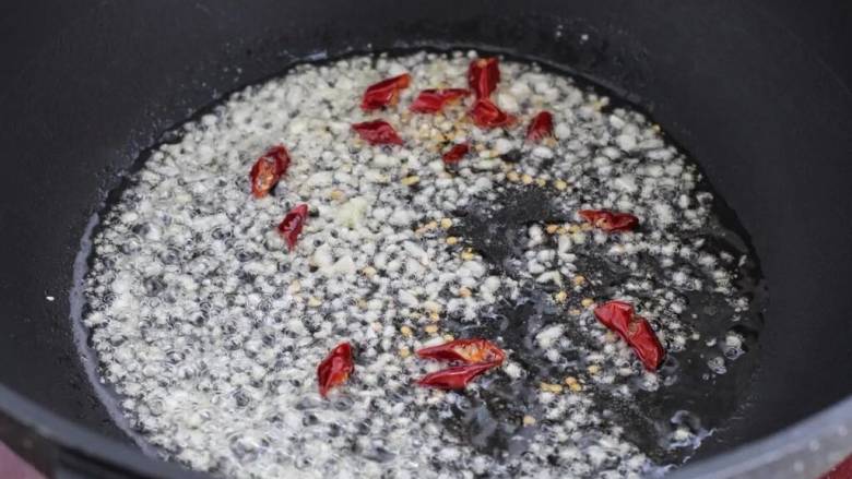 小炒毛豆,锅中倒入食用油烧热，下姜蒜末和红干椒小火炒出香味儿。