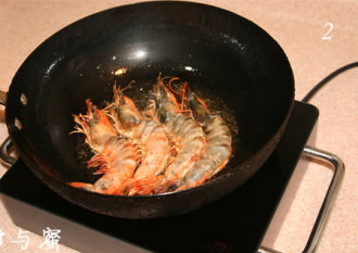 虾油焖大虾,对虾提前洗净，背部剖开约1公分，同时取出虾线，抹干水分，将该提前处理好的对虾放入锅中，煎至表面发红。