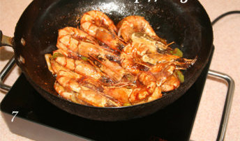 虾油焖大虾,轻轻逐只翻动锅内大虾，以便更好的与调料融合入味。