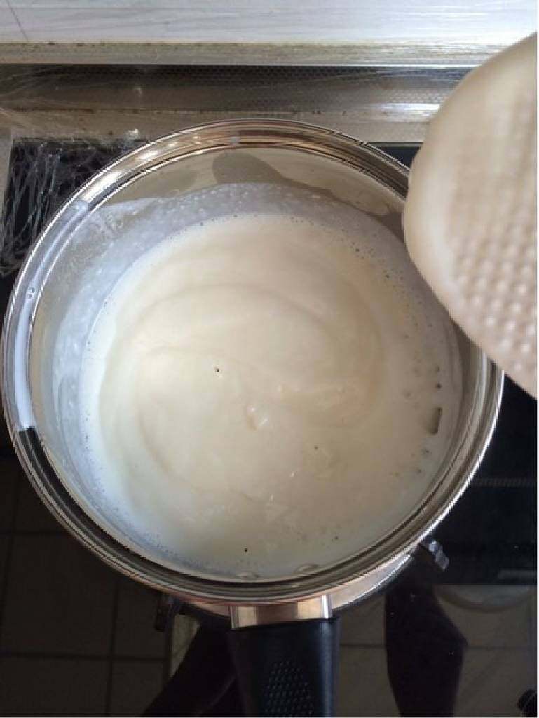 牛奶椰方块,然后迅速倒入之前搅拌好的玉米淀粉糊，继续加热，一边加热一边搅拌，注意不要糊锅噢，没一会就变成这样浓稠状态了，关火