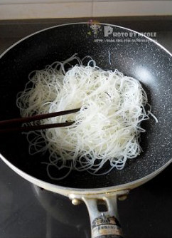 什锦素炒米线,锅烧热，加少许油，油烧热后放入米粉，迅速用筷子划散；