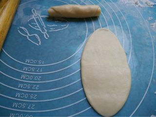 酥皮鲜肉月饼,如图将面团取出按扁用擀面仗擀成牛舌状由上而下卷好