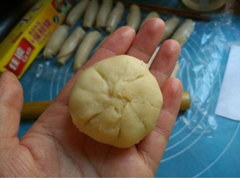 酥皮鲜肉月饼,如图将口捏紧，将肉饼轻轻按扁成月饼状，然后在中心用手指按压一下