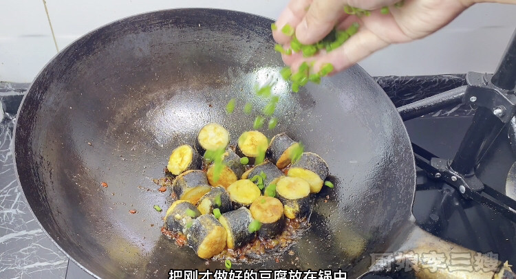 外焦里嫩的海苔豆腐卷儿制作方法,倒入海苔豆腐撒上香葱花翻炒均匀