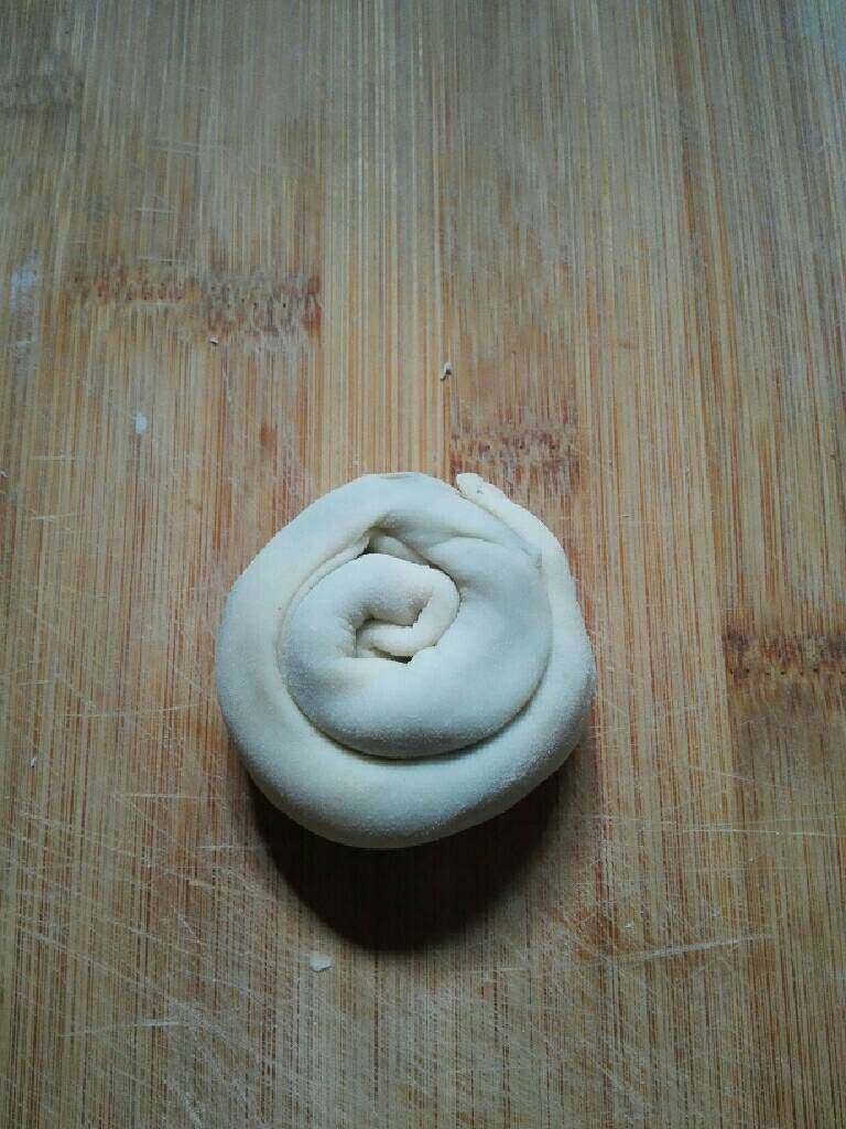 烫面葱花饼,再从一边卷起成圆形。