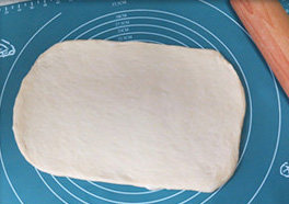 日式香浓炼乳面包,发好后的面团取出排气，擀成长方形