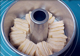 日式香浓炼乳面包,模具内抹薄薄一层黄油，将8等份小面团竖起来垂直贴着烟囱排入模具内