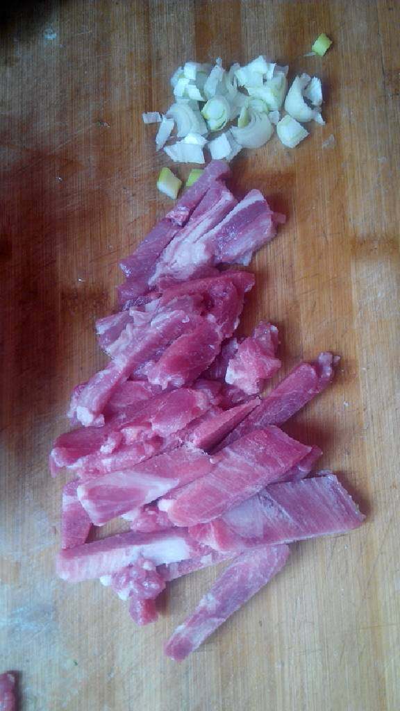 青椒蘑菇炒肉,猪瘦肉从冰箱拿出化冻，切成长条，葱切碎备用。