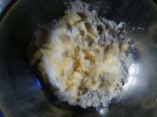 猫爪饼干,容器里放入低筋面粉和糖粉，再加入切小丁的黄油。