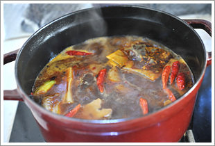 香辣猪蹄火锅,一个小时后，放入盐调味，继续再煮40分钟左右即可。如果汤太少的话可以补充热水。