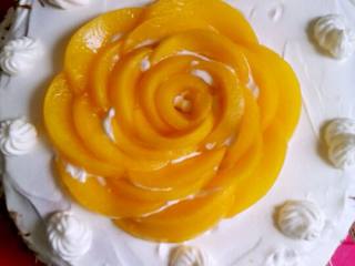 巧克力黄桃花型蛋糕,反复如图，尽量做成光滑的表面。用黄桃片摆成花型进行装饰，在蛋糕侧面，撒上巧克力碎。用奶油装饰一下。