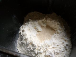 南瓜面包,如图面包机桶里依次放入牛奶鸡蛋南碎泥！一边角放糖一边角放盐！再放入面包粉挖个小凹坑放入酵母在盖上启动和面程序20分钟