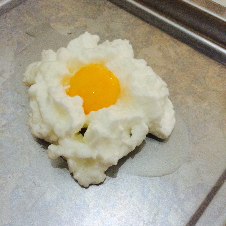 火山蛋,烤盘涂少许食用油 将发泡的鸡蛋放在盘中 中间留个凹洞 将蛋黄放进
