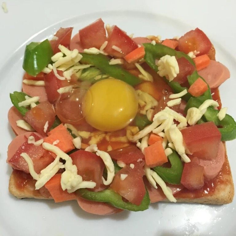 微波炉吐司披萨,如图用勺子在吐司中间压一个坑，打入鸡蛋，这样可以避免蛋液流失