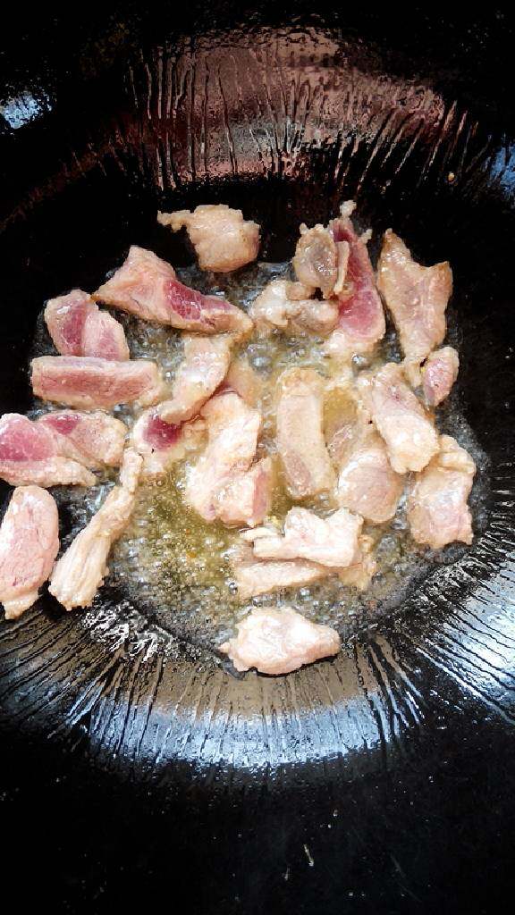 胡萝卜尖椒鸡蛋炒肉,锅内倒油，放入猪肉翻炒至微微变色。