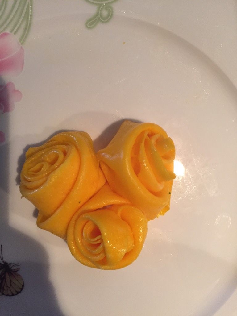 玫瑰鸡蛋饼,把蛋黄饼的边用小刀稍作修理，划成小长条，用一条的尽头开始转，转成三圈后往后折叠继续转成玫瑰花的形状装入碟中