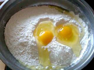 韭菜鸡蛋饼,舀入适量面粉和韭菜丁儿一同放入稍大容器中，再打入鸡蛋；