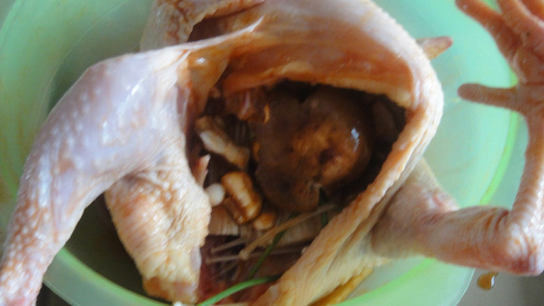 奥尔良烤鸡,把香菇、金针菇、小葱塞进鸡肚里再把盆里的料汁加入一点进去