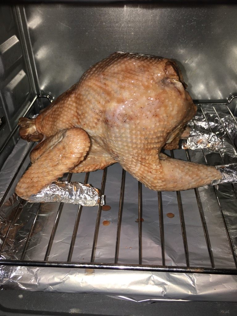 蜜汁烤鸡,如图就可以把鸡放进去烤了，烤盘用锡纸包起来，一会烤的时候用来接住烤鸡滴出来的油，以便好做卫生。大概20分钟拿出来刷一次蜂蜜，共刷三次。