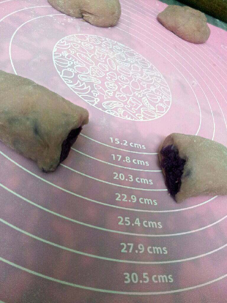 紫薯面包,用小刀切开一分为二，用擀面杖沾点水沾点白芝麻，转沾在紫薯中心，