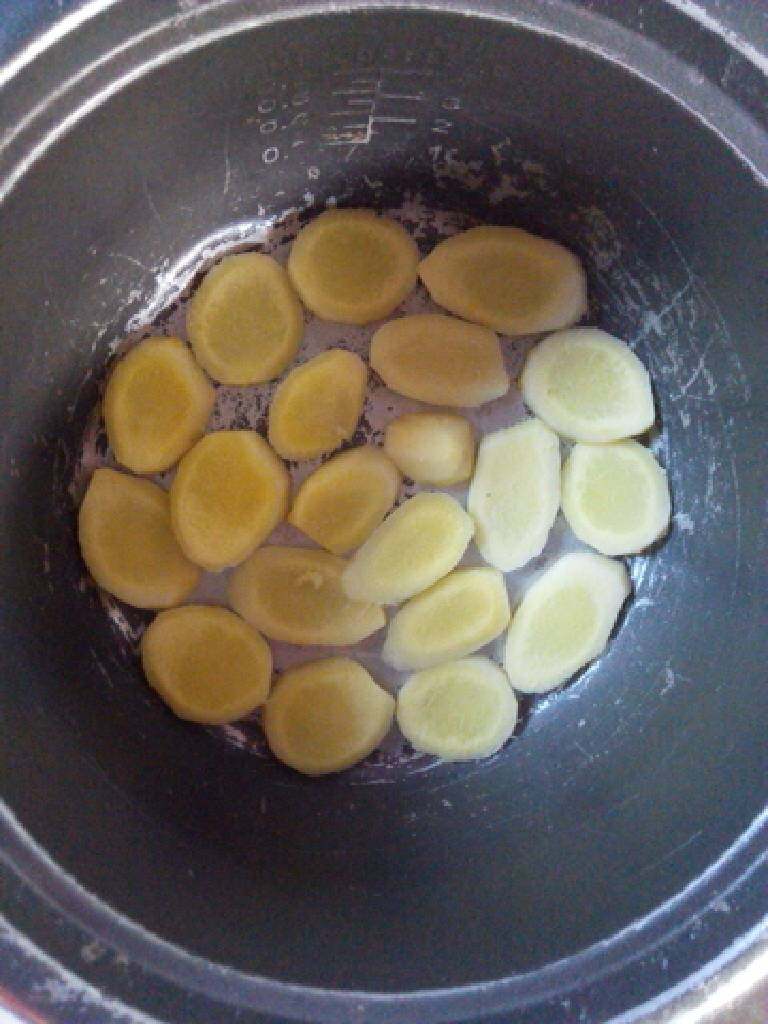 电饭煲焗鸡,电饭煲烧放一点食用油，把姜片铺满电饭煲内，放点葱也可以。