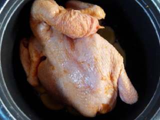电饭煲焗鸡,取出鸡，用厨房纸擦干水份，放电饭煲内，盖盖，按煮饭档。