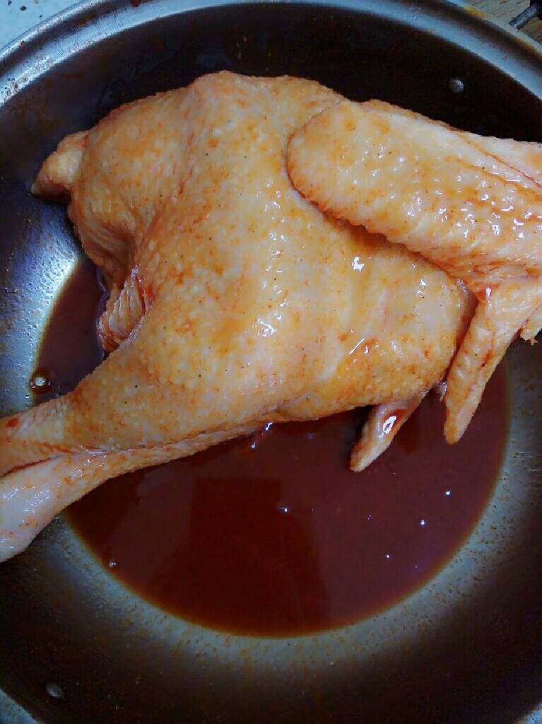 奥尔良烤鸡,用牙签或粗针向鸡身扎孔，以便入味。用烤肉酱汁均匀涂抹鸡身，反复多次按摩鸡身，鸡胸里塞入切好的姜片。