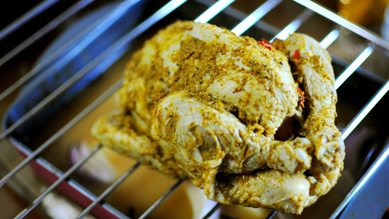 印度风味烤鸡,烤盘放下层，中层架烤架，将腌好的鸡放在烤架上（烤盘的上方）。大只鸡烤75分钟。
