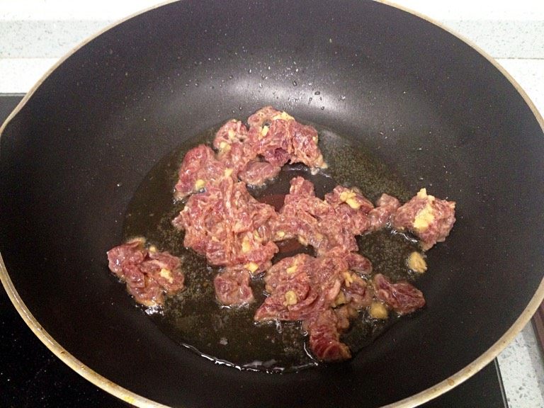 兰豆炒牛肉,热油锅，把牛肉爆炒至五成熟，盛出，锅里剩一点油。