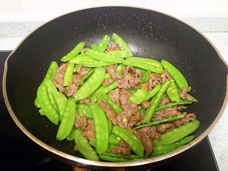 兰豆炒牛肉,倒入牛肉，小火翻炒拌匀，补半勺生抽增色增香。