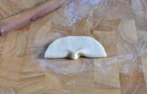 奶香荷叶饼,对折成半圆形，并用手指在半圆形的底边中间捏出一个”荷叶柄“；