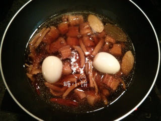 墨鱼干红烧肉,压好以后从高压锅中转入炒锅中，加入两只白煮蛋（剥壳后在表面划几刀入味）；