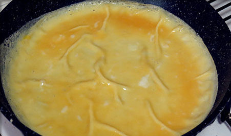 茄汁蛋包饭,锅里薄薄抹一层油，鸡蛋加入摊成蛋饼