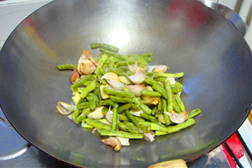 毛蒜鱿鱼烧草虾,另起锅，放入已经炸熟的毛蒜和豆角。