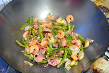 毛蒜鱿鱼烧草虾,再放入已经炸熟的虾仁和鱿鱼须子翻炒均匀。
