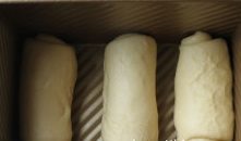 牛奶软吐司,将卷好的面团排入吐司模中，放温暖湿润处进行发酵；