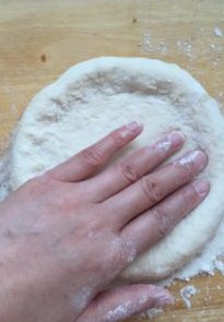 夏威夷披萨,双手向四周推开饼皮，形成四周厚中间薄的饼身。