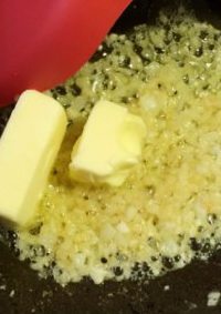 香蒜面包结,待蒜末呈浅金黄色时，加入剩余黄油炒至融化。